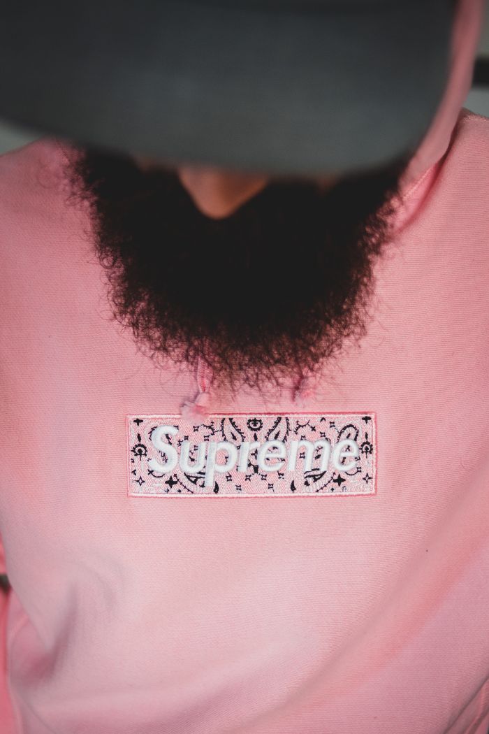 about-img Close-up of a stylish pink hoodie featuring bold logo design and sharp fashion aesthetic.